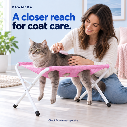 Cat being gently brushed in the pink grooming hammock — AI usage illustration